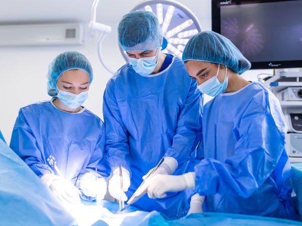 Group of medical team urgently doing surgical operation and helping patient in theater at hospital. Medical team performing surgical operation in a bright modern operating room